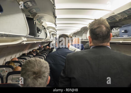 Passagiere, die darauf warten, zu, aussteigen, und, Ihre, Gepäck, aus, Overhead, Fächer, an, Manchester, Flughafen, nach, Ankunft, ein, eine, Brussels Airlines, Flug, Stockfoto