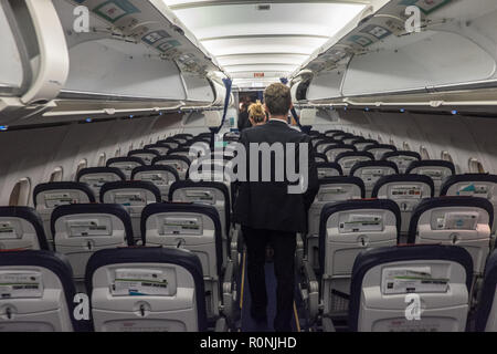 Passagiere, die darauf warten, zu, aussteigen, und, Ihre, Gepäck, aus, Overhead, Fächer, an, Manchester, Flughafen, nach, Ankunft, ein, eine, Brussels Airlines, Flug, Stockfoto