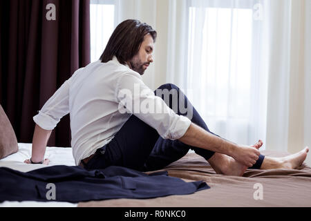 Schön schöner Mann sitzen auf dem Bett Stockfoto