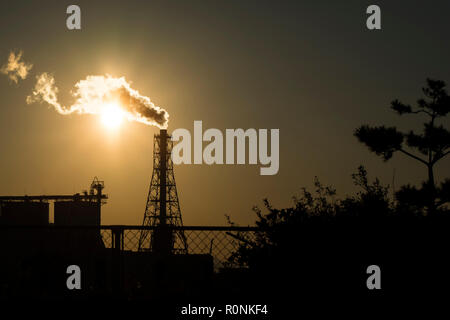 Factory Schornstein abgibt oder Entladungen schwere raucht bei Sonnenuntergang Erstellen von Umweltverschmutzung. Stockfoto