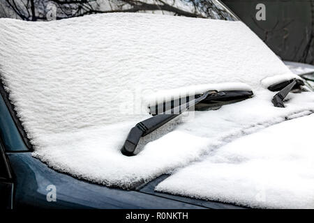 Schnee auf der Vorderseite des Fahrzeugs. Der erste Schnee im November. Stockfoto