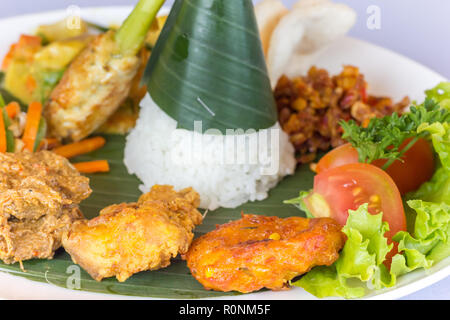 Nasi Campur Bali mit Tempeh, Huhn und Gemüse, serviert auf einem Bananenblatt Stockfoto