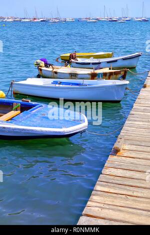 Kleine Boote an einer hölzernen Steg auf einem hellen, blauen Meer Stockfoto