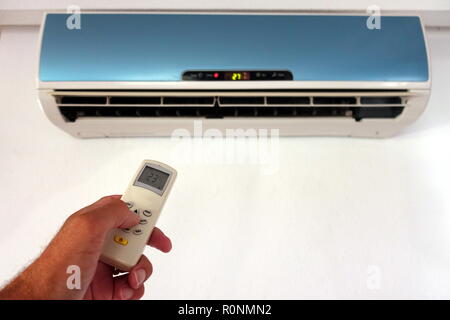 Jemand Ändern der Einstellungen eines inländischen AC oder Klimaanlage mit Fernbedienung - Fokus auf die Remote-copy Platz für Text Stockfoto