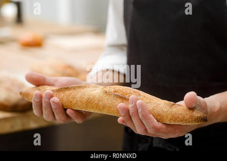 Der Mensch ist mit Baguette Stockfoto