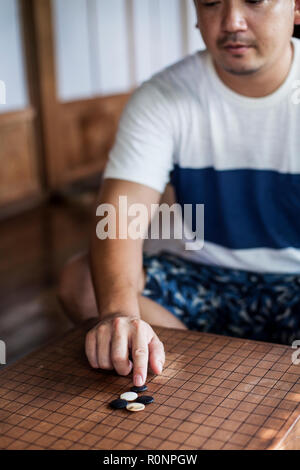Hohe Betrachtungswinkel von zwei japanische Männer sitzen auf dem Boden, spielen gehen. Stockfoto