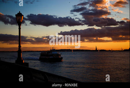 Ein Taxi zum Battery Park City Ferry Terminal hetzen, auch als World Financial Center Ferry Terminal. Kleine Segelboote und die Statue von Lib Stockfoto