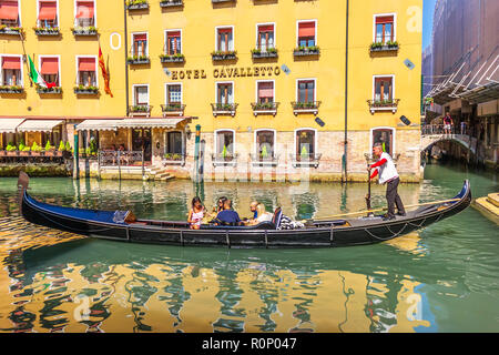 Venedig, Italien - 22 August, 2018: ein gondoliere in einer Gondel mit Touristen vor ein schickes Hotel Stockfoto