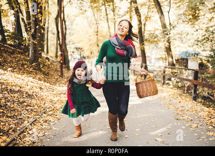 Eine junge Mutter mit einem Kleinkind Tochter im Wald im Herbst Natur. Stockfoto