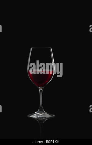 Glas Rotwein auf schwarzem Hintergrund Stockfoto