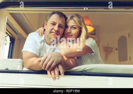 Glückliches Paar von Touristen in einem Wohnmobil im Sommer sitzen. Jahrgang, getönt. Stockfoto