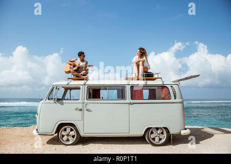 Junge Leute auf dem Dach des im Retrostil minivan Zeit toget Stockfoto