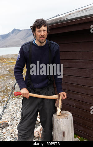 Ein Polizeioffizier hackt Holz außerhalb seiner isolierten Station als Teil seines Jobs die remote Isfjorden in Svalbard, in der Arktis zu schützen. Stockfoto