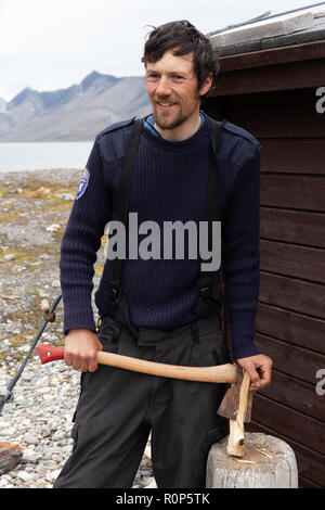 Ein Polizeioffizier hackt Holz außerhalb seiner isolierten Station als Teil seines Jobs die remote Isfjorden in Svalbard, in der Arktis zu schützen. Stockfoto