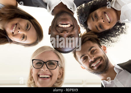 Low Angle Shot von Angeregten arbeiten Mitarbeiter im Kreis stehend Stockfoto