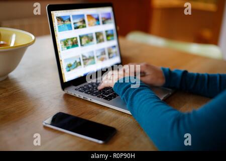 In der Nähe von Frau Hände schreiben auf Tastatur auf dem Küchentisch Stockfoto