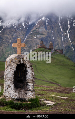 Gergeti Kirche drastisch thront auf einem Hügel im Kaukasus, in Kazbegi, Georgia. Stockfoto