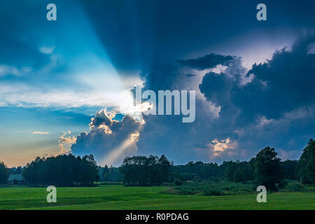 Bewölkter Sonnenuntergang mit Sonnenstrahlen. Stockfoto