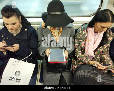 Kiew, Ukraine. 6 Nov, 2018. Frauen benutzen elektronische Geräte in einer U-Bahn in Kiew, Ukraine, 06. November 2018. Credit: Serg Glovny/ZUMA Draht/Alamy leben Nachrichten Stockfoto