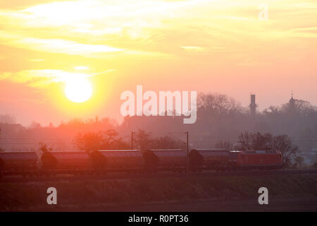 Drosa, Deutschland. 07 Nov, 2018. Ein Güterzug rollt durch die Osternienburger Land in Anhalt-Bitterfeld bei Sonnenaufgang. Die Grafschaft hat einen goldenen November Tag vor sich. Die Sonne soll scheinen den ganzen Tag lang. Credit: Klaus-Dietmar Gabbert/dpa-Zentralbild/ZB/dpa/Alamy leben Nachrichten Stockfoto