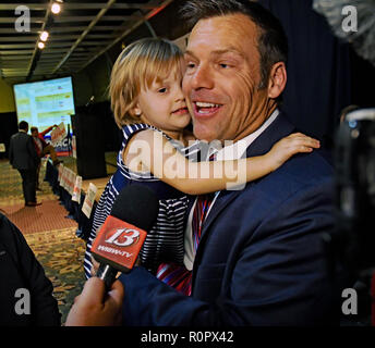 Topeka Kansas, USA, November 6, 2018 Kansas Staatssekretär Kris Kobach hält seine jüngste Tochter, während im Gespräch mit den Medien nach Beendigung seiner Konzession Ausführungen heute abend Credit: Mark Reinstein/MediaPunch Stockfoto