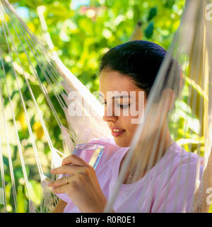 Junge Frau mit einem Glas Wasser, tropischen Garten, Guadeloupe, Französisch Westindien, Stockfoto