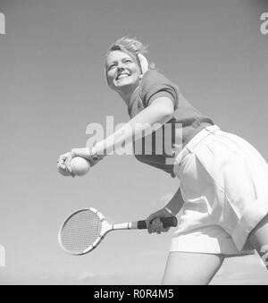 Tennis in den 1940er. Die junge Schauspielerin und Model Haide Göransson, 1928-2008, spielt Tennis, trägt ordentliche Tenniskleidung. Weiße Shorts und ein Pullover. Sie ist bereit, den Ball zu servieren. Schweden 1946. Foto Kristoffersson Ref. U142-6 Stockfoto