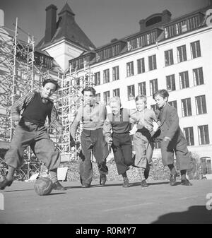 1940er Jahre Jungen Fußball spielen. Eine Gruppe von Jungen in typische 1940 gekleidet s Hose Fußball spielen auf dem Schulhof. Schweden 1940 s Foto Kristoffersson ref AE 25-4 Stockfoto