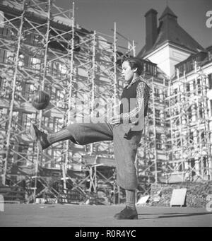 1940er Jahre Jungen Fußball spielen. Ein Junge in typischen 1940 gekleidet s Hose spielt mit seinem Fußball auf dem Schulhof. Schweden 1940 s Foto Kristoffersson ref AE 25-10 Stockfoto