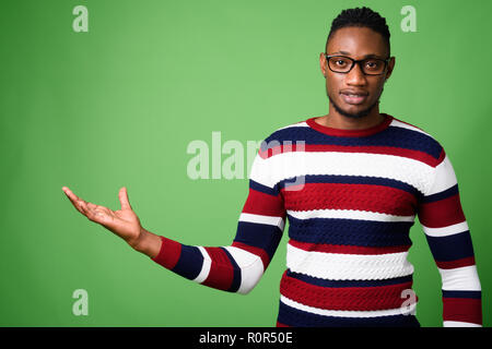 Jungen schönen afrikanischen Mann aus Kenia gegen grüner Hintergrund Stockfoto