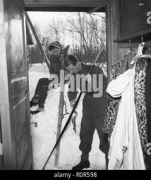 Winter in den 1940er. Ein junges Paar geht Ski fahren und bereitet die Skier mit Ski-Wachs zu, um bessere Traktion auf dem Schnee zu erhalten. Schweden 1943. Foto Kristoffersson Ref. D115-4 Stockfoto