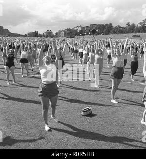 Gymnastik in den 1950er Jahren. Die beliebten Frauen Hausfrau Gymnastik wird überall praktiziert. Hier eine große Anzahl von Frauen zusammen trainieren im Freien. Schweden Juni 1954 Stockfoto