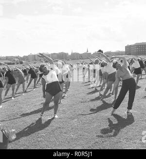 Gymnastik in den 1950er Jahren. Die beliebten Frauen Hausfrau Gymnastik wird überall praktiziert. Hier eine große Anzahl von Frauen zusammen trainieren im Freien. Schweden Juni 1954 Stockfoto