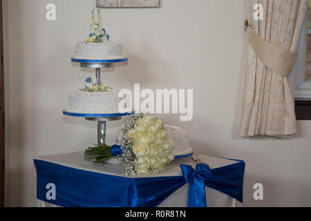 3 tier Hochzeitstorte, drei Reihen von weißen iced Hochzeitstorte mit Farbband und Blumen Dekoration jedes Tier. Stockfoto
