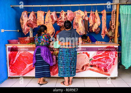 Santiago Sacatepequez, Guatemala - November 1, 2018: Indigene Maya Frauen in traditioneller Kleidung Shop bei Metzger shop auf Allerheiligen. Stockfoto