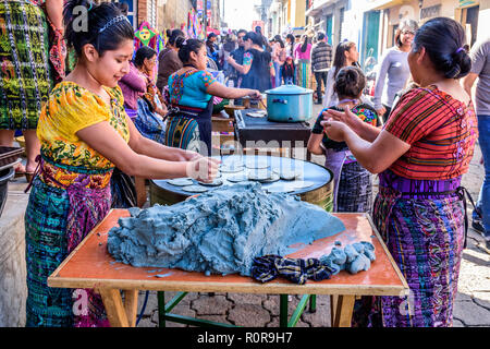 Santiago Sacatepequez, Guatemala - November 1, 2018: indigene Frauen in traditioneller Kleidung, Tortillas in Straße auf Allerheiligen. Stockfoto