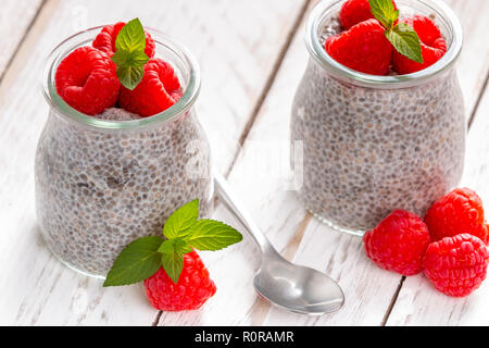 Nahaufnahme des serviert Glas Gläser mit süßen Pudding von Chia Samen gefüllt und mit frischen Himbeeren und Minze garniert Stockfoto