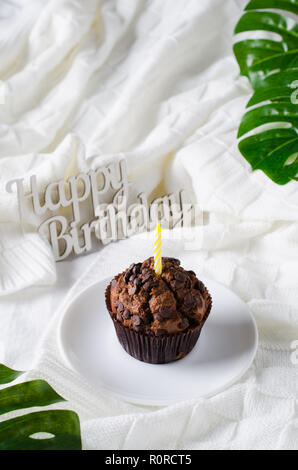 Geburtstag Muffins oder capkakes mit Schokolade auf einem hölzernen Fach im Bett. Weißer Hintergrund. Süße Speisen. Festliche Stimmung Kopie Raum flach Stockfoto