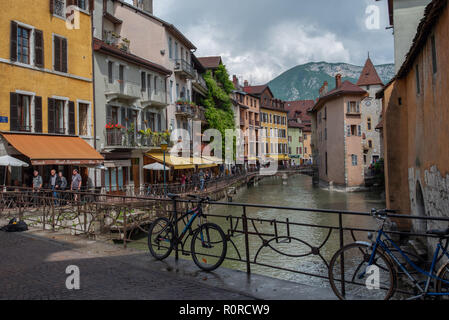 Fahrräder angekettet an die Geländer über eine Brücke, während die Thiou Fluss fließt durch malerische Annecy, Frankreich. Stockfoto