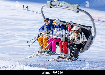 Sotschi, Russland - Januar 20, 2013: Vier Personen Fahrt auf Stuhl Skilift an sonnigen Wintertag im Kaukasus. Skipisten von Gorki Gorod Mountain Ski Stockfoto