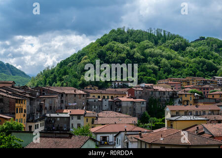 Blick auf den grünen Hügeln über Castelnuovo di Garfagnana gesehen über die Dächer Stockfoto