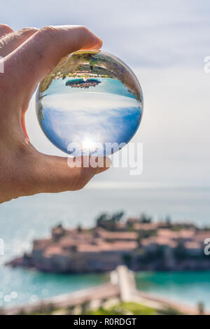 Historische Altstadt in Sveti Stefan große transparente Glaskugel wider, Küste von Montenegro Stockfoto