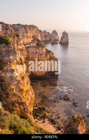 Sonnenaufgang über dem Meer, an der felsigen Küste von Sandstein, Felsformationen im Meer, Algarve, Lagos, Portugal Stockfoto