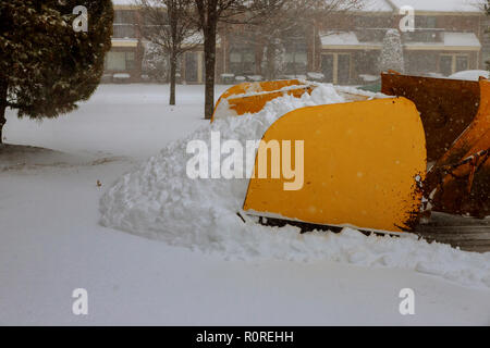 Schnee Kehrmaschine arbeitet auf der schneebedeckten Straße mit Tieflöffel entfernt Schnee von Stockfoto