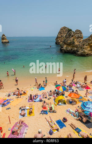 Touristen und Badegäste am Sandstrand Praia do Camilo, felsigen Küste der Algarve, Lagos, Portugal Stockfoto