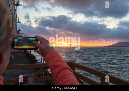 Astoria-Megler Bridge im Licht des Sonnenuntergangs und eine touristische Handy Kamera Stockfoto