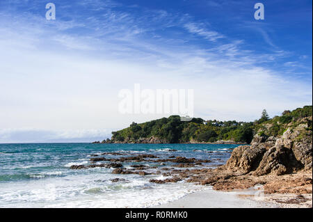 Waiheke Island, Neuseeland. Malerische Bucht von üppigem Grün mit blauem Himmel Hintergrund umgeben Stockfoto