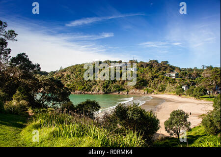 Waiheke Island, Neuseeland. Malerische Bucht von üppigem Grün mit blauem Himmel Hintergrund umgeben Stockfoto