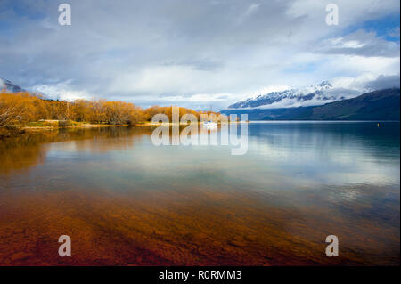 Glenorchy und den Lake Wakatipu, Neuseeland. Spektakuläres Panorama, das klare Wasser, die Farben des Herbstes und die schneebedeckten Berge im Hintergrund Stockfoto