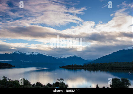 Wunderschöne Aussicht auf Lake Te Anau und die Murchison Berge von Te Anau Downs. Sonnenuntergang über dem See mit schönen rosa Wolke Reflexionen Stockfoto